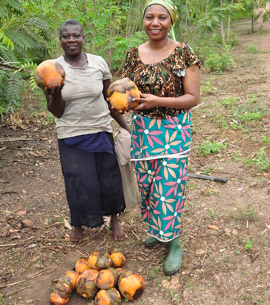 photo of two women holding large fruits